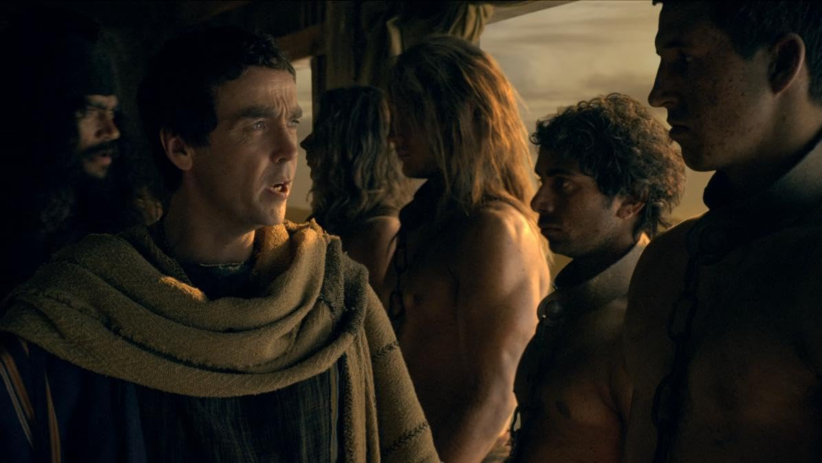 Sam Barton as Captured Warrior opposite John Hannah in Spartacus: Gods of the Arena (2011).