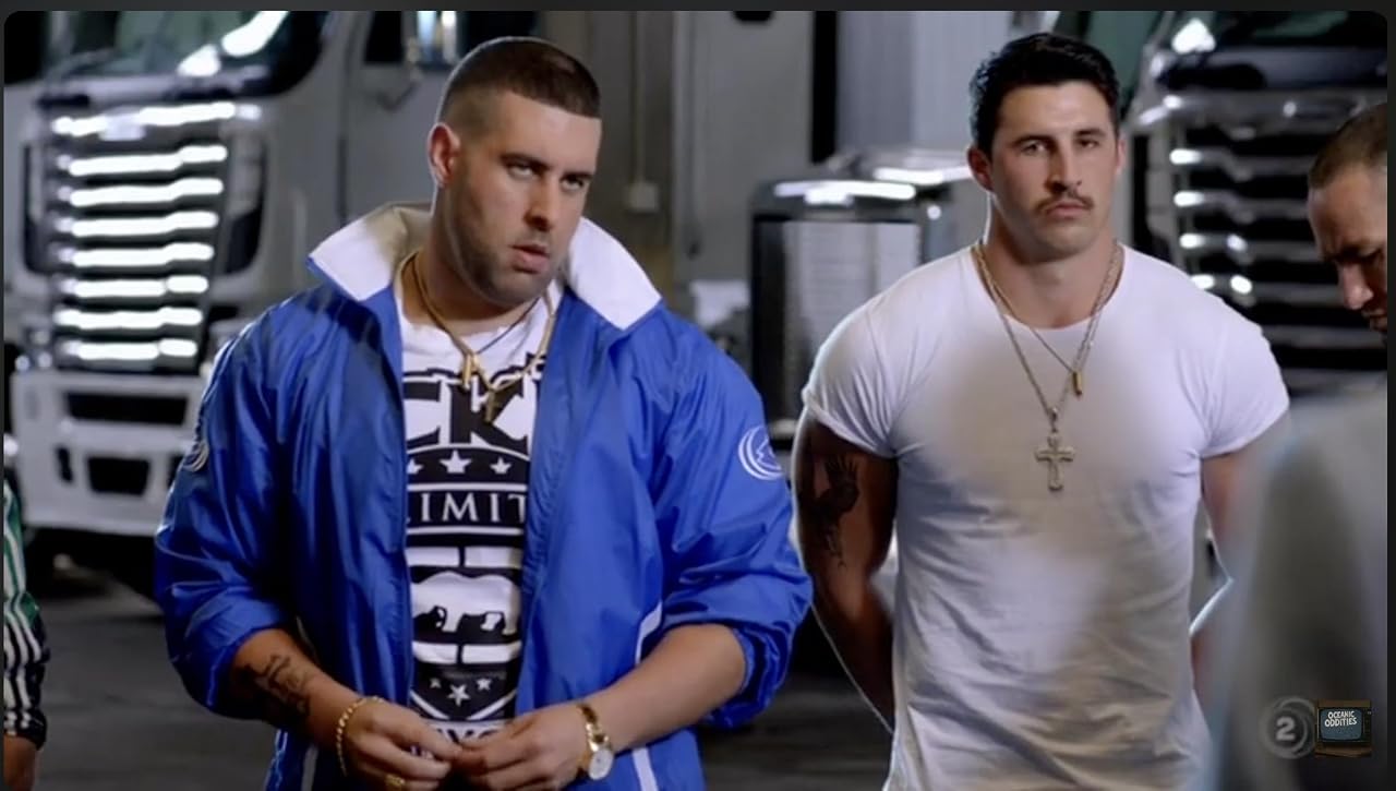 Sam Barton as Gangster Rapper in Terry Teo, wearing a white T-shirt beside another character.